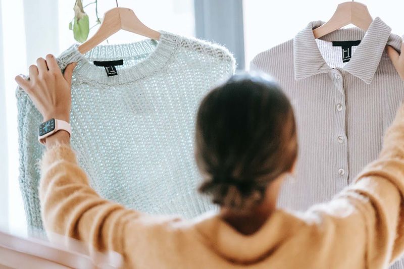 A woman deciding between two shirts