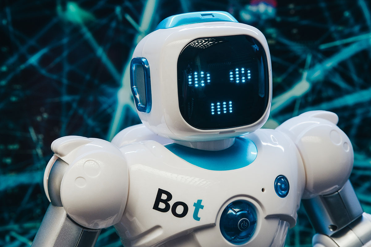 An AI-powered robot that's white in color with digital googly eyes that makes his face look like a lightbright toy that you might have played with as a child.