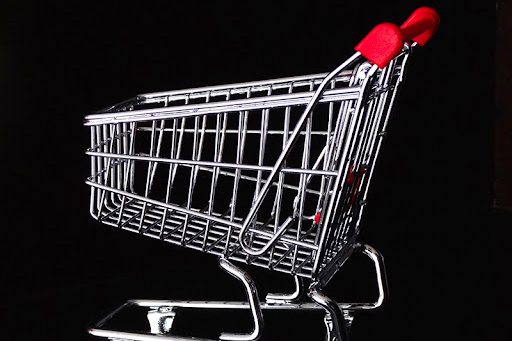 A shopping cart with a red handle