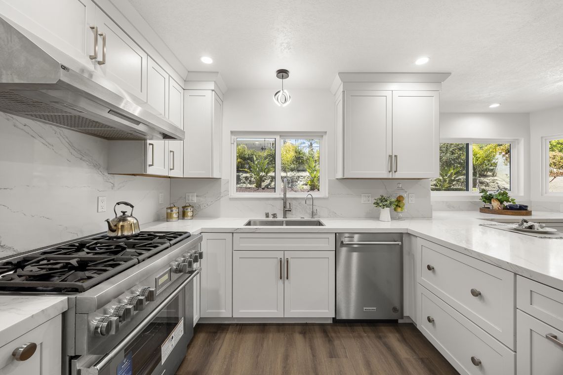 Chef's kitchen with white shaker cabinets and stainless appliances