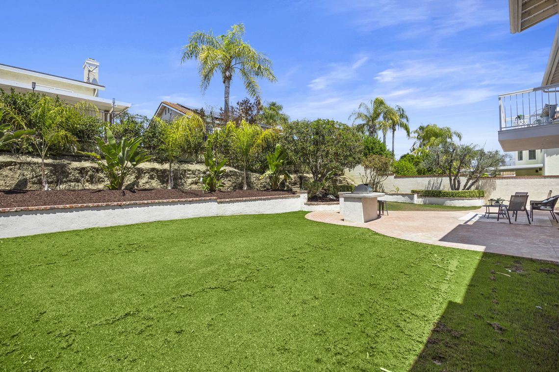 Entertainer's backyard with built-in BBQ and artificial turf