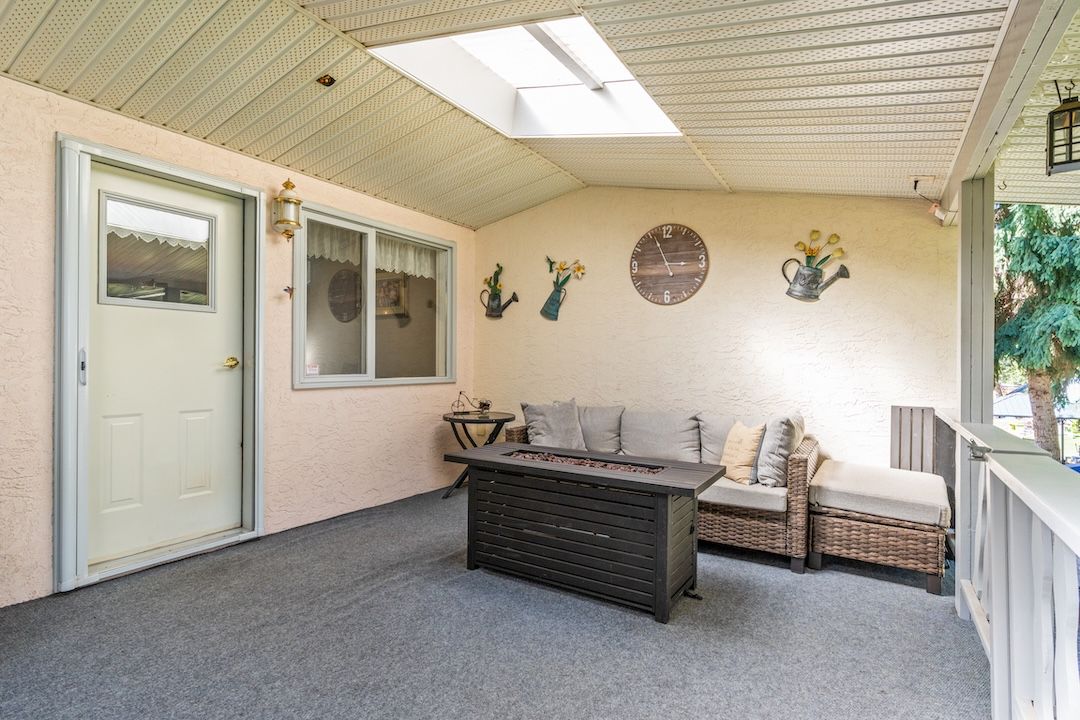 Covered deck with a fire table and lounge seating