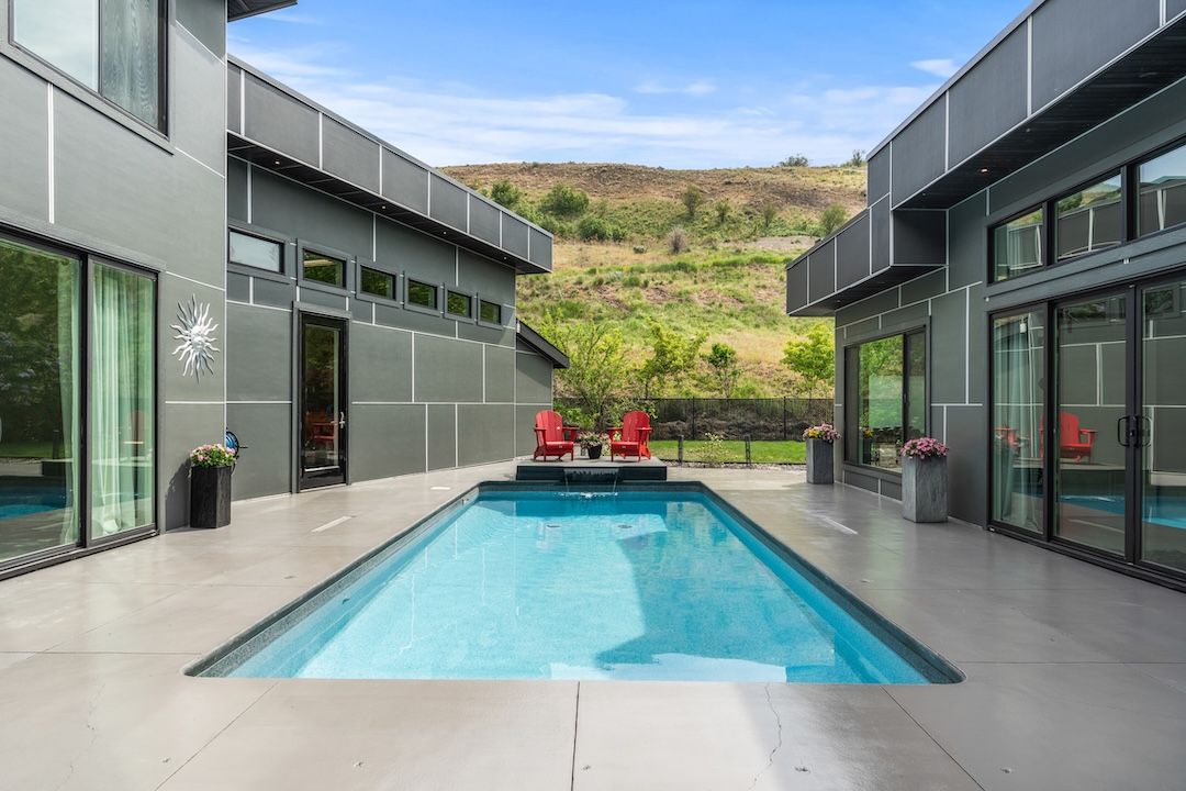 The private courtyard with heated inground pool and red Adirondack chairs