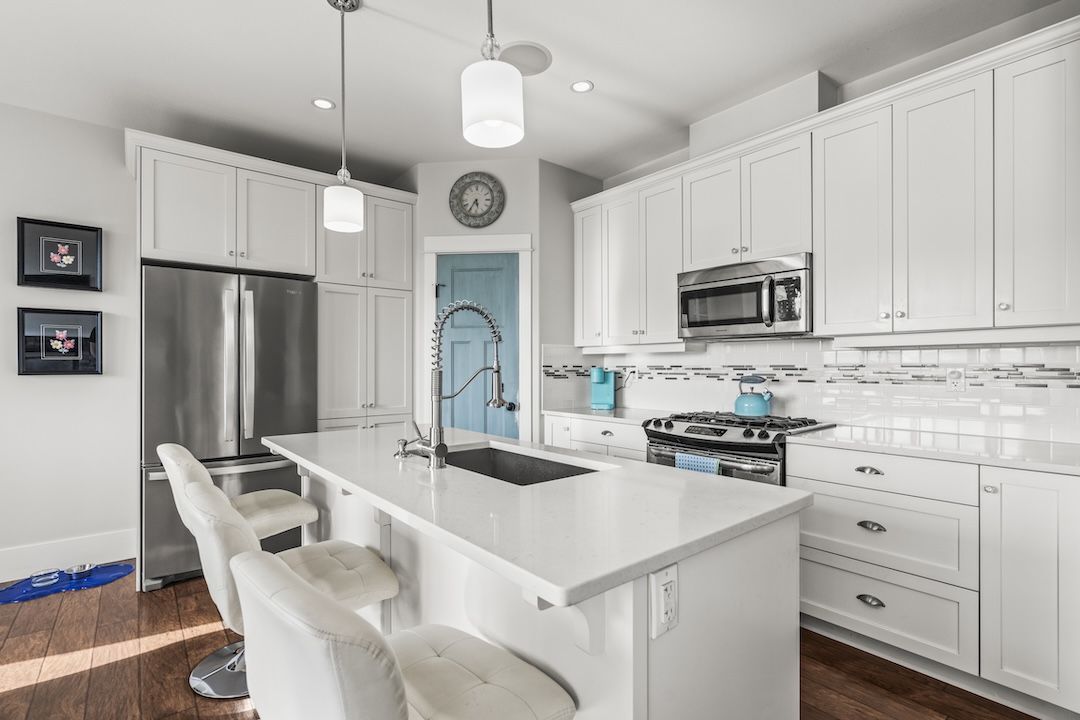 Main floor kitchen with island, looking out across the dining and living rooms