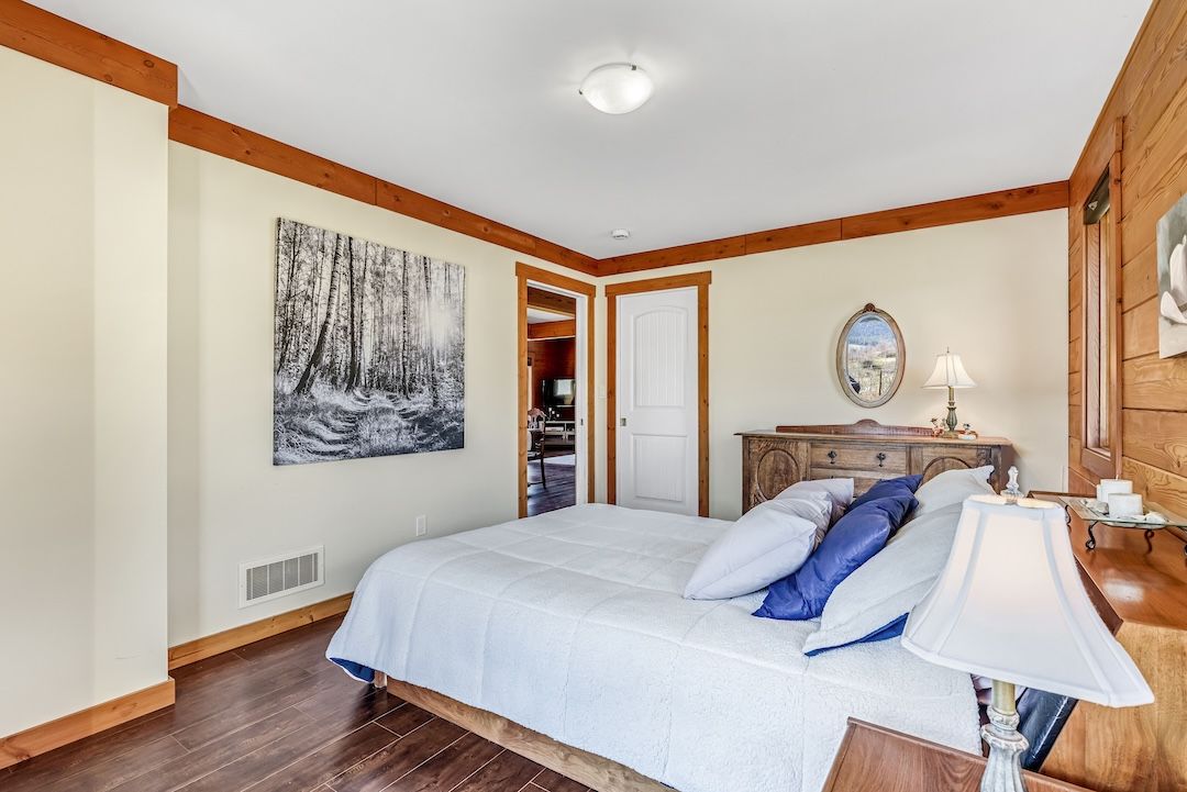 Upper-floor bedroom under the wood ceilings at 9371 Highway 6, Coldstream BC