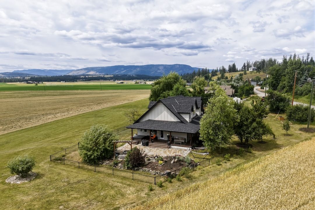 Aerial view of the patio, yard, and surrounding fields