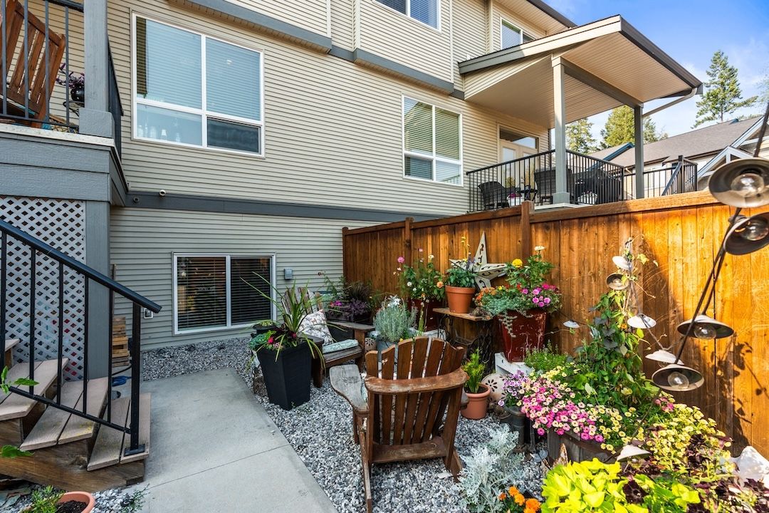 Private fenced backyard with raised garden beds and a sitting area
