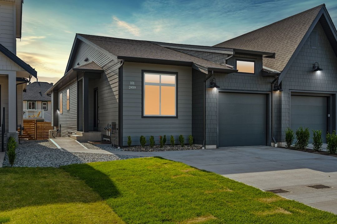 Twilight exterior of Unit 101, 2459 Bradley Drive — a Wesmont Homes half duplex at Rosemont, Armstrong BC