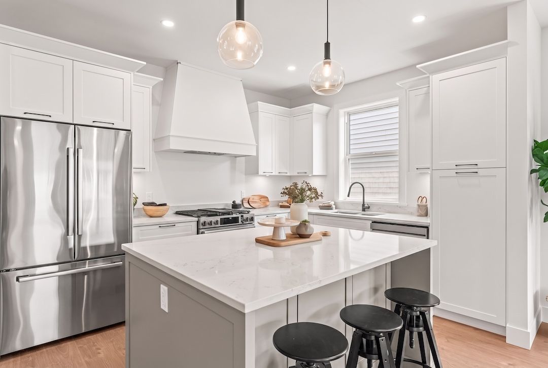 Kitchen with quartz island, shaker cabinetry, and black hardware