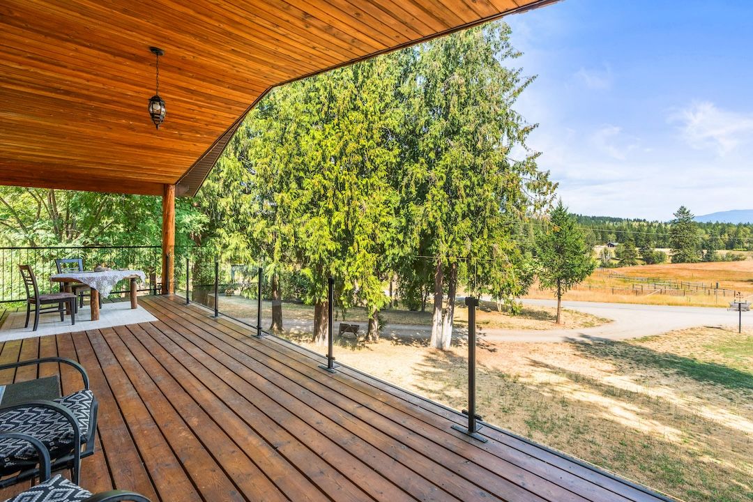 Covered upper deck with glass railings looking over the valley