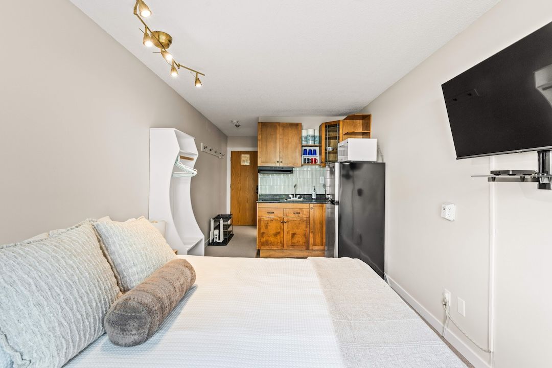 Looking back from the bed toward the kitchen and TV