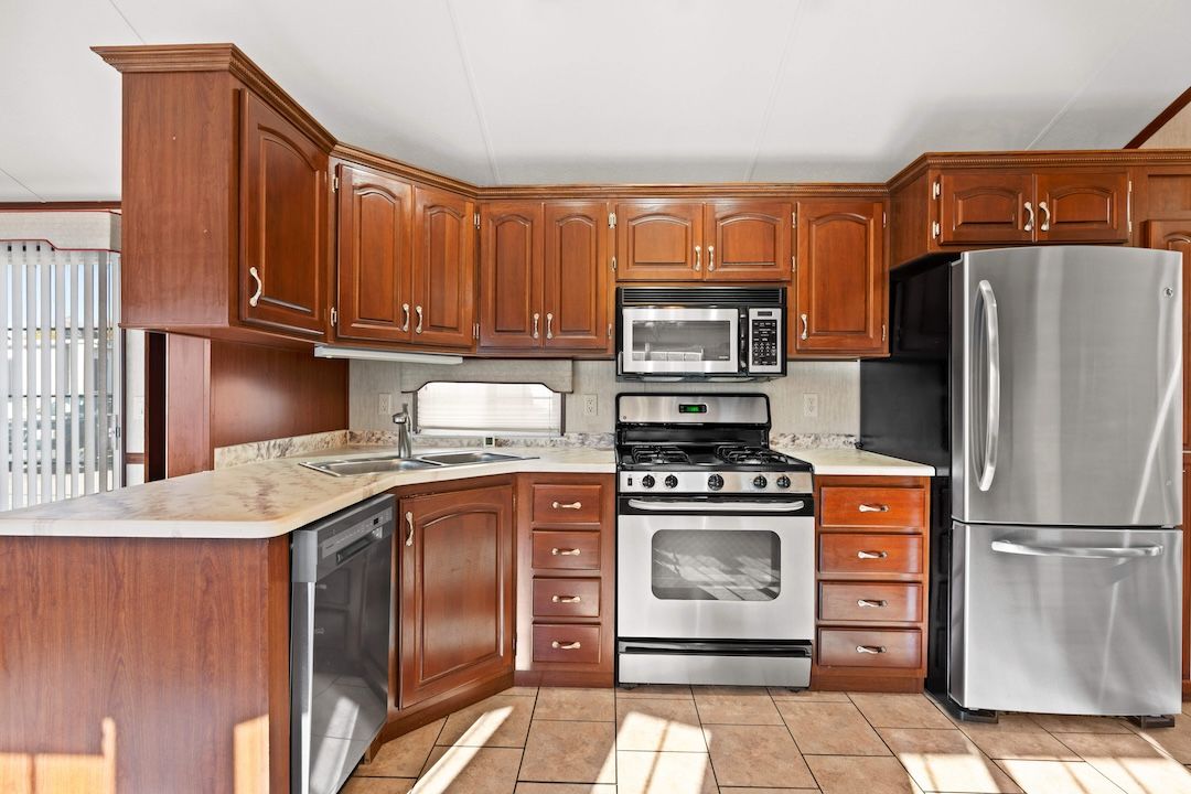 Kitchen with wood cabinetry, gas range and stainless fridge