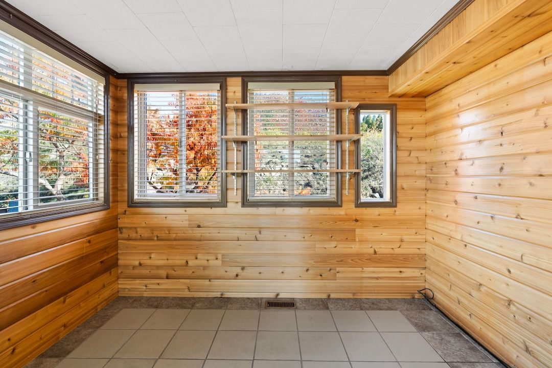 Wood-panelled sunroom with windows on three sides