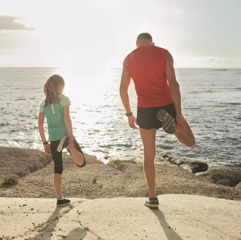 father and daughter stretching during jogging