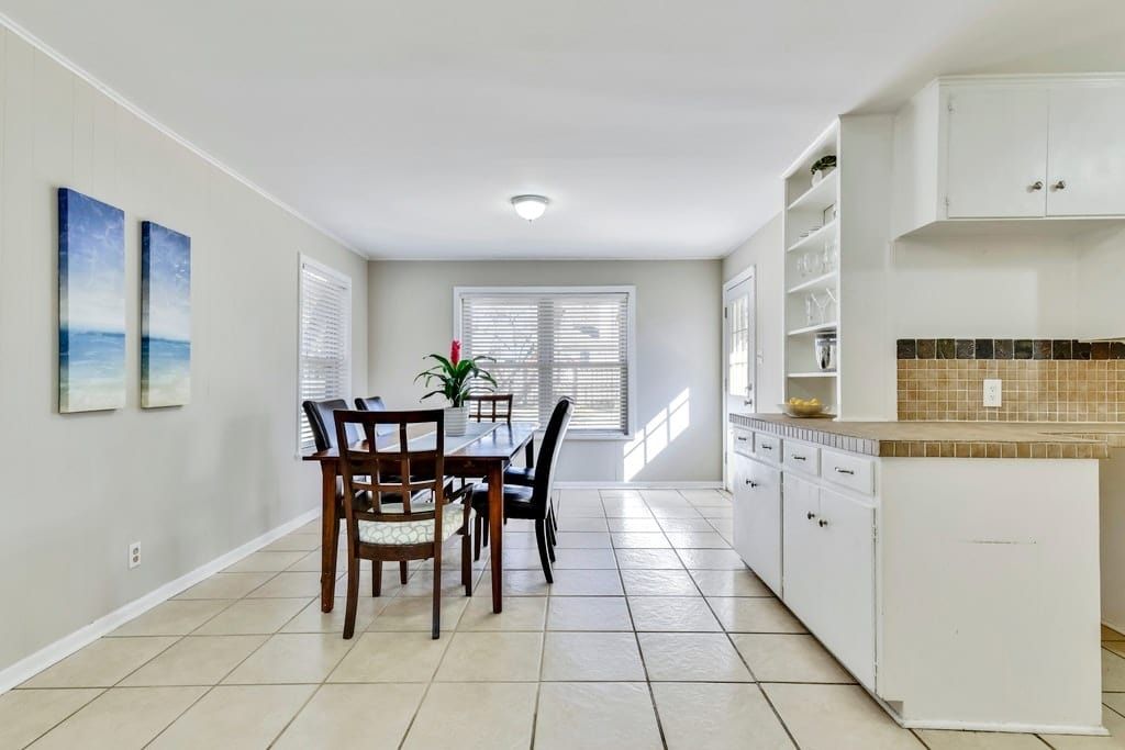 The kitchen is designed with neutral tile and earthy accents.